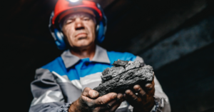 Coal miner holding coal.