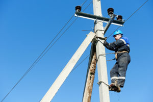 Lineman climbing work on electric post power pole.