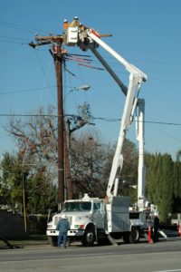 Utility workers using bucket truck.