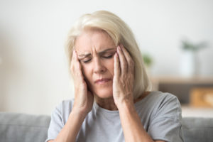 Elderly woman in Alabama suffering from a headache due to Elmiron.